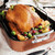 The Nordic Ware Extra Large Non-Stick Roasting Pan and Rack with a roasted turkey