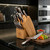 The Hammer Stahl 12 piece cutlery essentials set on a kitchen counter next to a cutting board with diced vegetables.