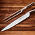 The Hammer Stahl Carving Knife & Fork Set on a wood cutting board