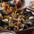The FINEX 14-inch cast iron skillet filled with paella on a table.