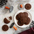 Chocolate cookies made with the Nordic Ware Halloween cookie stamps on a plate on a Halloween-decorated table.