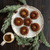 An overhead shot of mini bundt cakes baked in the Nordic Ware Wreathettes Pan on a plate on a holiday decorated table