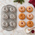 Six wreathlette cakes baked in the Nordic Ware Wreathlettes Pan are being decorated.