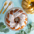 An overhead view of a glazed Bundt cake made with the Nordic Ware 75th Anniversary Braided Bundt Pan on a table