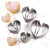 The 4 RSVP Endurance Heart-Shaped Biscuit Cutters with heart-shaped biscuits and pink sprinkles on a white table.