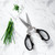 The Black Messermeister 8 Inch Take Apart Kitchen Scissors on a marble counter with some chives