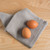 The Now Designs Ripple London Gray Cotton Dish Cloths with eggs on a counter