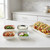 A set of the Now Designs Mix and Prep pinch bowls filled with taco garnishes alongside a serving tray of tacos.