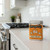 The Spicewalla Honey and Herb Rub tin is on a kitchen counter.