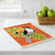 The Wet-It! toucan Swedish Cloth on a kitchen counter with a basket of green apples