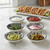 The six pinch bowls in the Now Designs black bits & dots pinch bowl set are filled with taco toppings.
