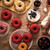 Red Bundtlette cakes made in the Nordic Ware Swirl Bundtlette pan on a wood table with the pan