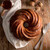 A cake baked in the Nordic Ware Swirl Bundt Pan, glazed with maple syrup