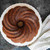 A cake baked in the Nordic Ware Swirl Bundt Pan sprinkled with powdered sugar