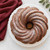 A cake baked in the Nordic Ware Swirl Bundt Pan, dusted with powdered sugar.