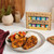 The  Spicewalla Signature Gift Set on a kitchen island with a chicken breast and veggies dinner.
