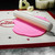 The Fat Daddio's Fondant Rolling Pin rolling pink fondant on a silicone baking mat