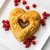 A cake baked in the Nordic Ware Floral Heart Bundt Pan with raspberries on a plate