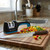 The Messermeister Pull Through Knife Sharpener on a kitchen counter with a chef knife