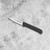 The Messermeister Clip Point 3 Inch Paring Knife on a marble counter