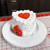A white decorated cake made in the Fat Daddio's 6 inch heart cake pan