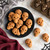 Skull cake bites made in the Nordic Ware Skull Bites Cakelet pan on a black plate.