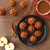 Mini cakes made in the Nordic Ware Lil pumpkins Cakelets pan on a plate and some cooking on a wire rack