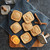 Cookies made with the Nordic Ware Fall Forest Springerle Cookie Stamps on a blue napkin next to orange slices and cinnamon sticks