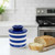 The Nautical Stripe Butter Bell Crock on a kitchen island with a buttered slice of a baguette