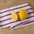 The Now Designs Red Stripe Dish Towel with lemons on a counter