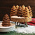 Six evergreen cakelets in a forest scene