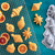 Cakelets made in the Nordic Ware Vintage Ornaments Cakelet Pan next to the pan and orange slices