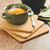 The Fox Run Square Cork Trivets Set with a crock of chili
