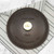 An overhead view of the top of the Lancaster No. 8 Cast Iron Lid on a kitchen towel on a marble counter