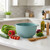 A Rosti Margrethe Pebble Green mixing bowl on a kitchen counter with the ingredients to make a salad