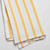 A closeup view of a folded Now Designs Lemon Yellow Stripe Dish Towel