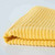 A closeup view of a folded Now Designs Ripple Lemon Yellow Dish Cloth