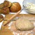 The Norpro Danish Dough Whisk next to baked bread and pizza dough