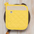 A Now Designs Superior Yellow Pot Holder on a skillet