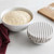 A white bowl with proofing dough and another bowl covered with one of the Now Designs Ticking Stripe Bowl Covers.