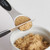 The leveler leveling 1/2 a tablespoon of brown sugar.