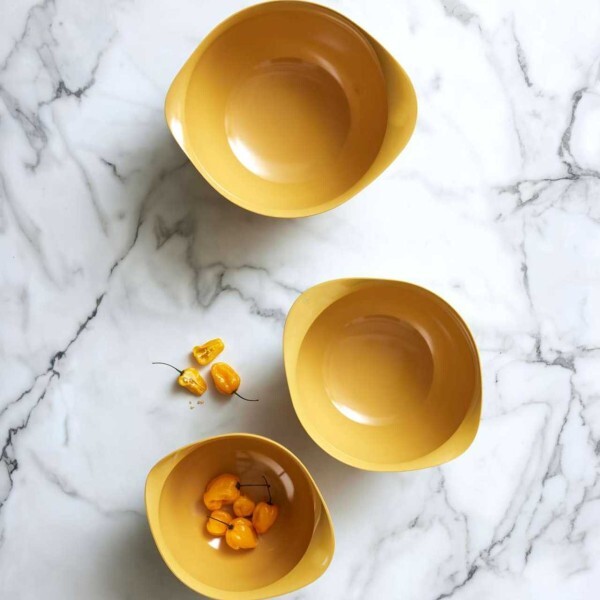 An overhead view of three Rosti Margrethe curry yellow mixing bowls