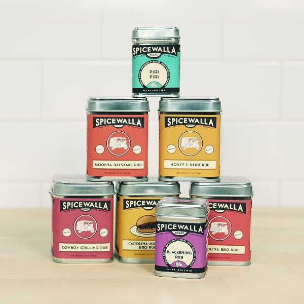 Spicewalla big tins stacked on a kitchen counter