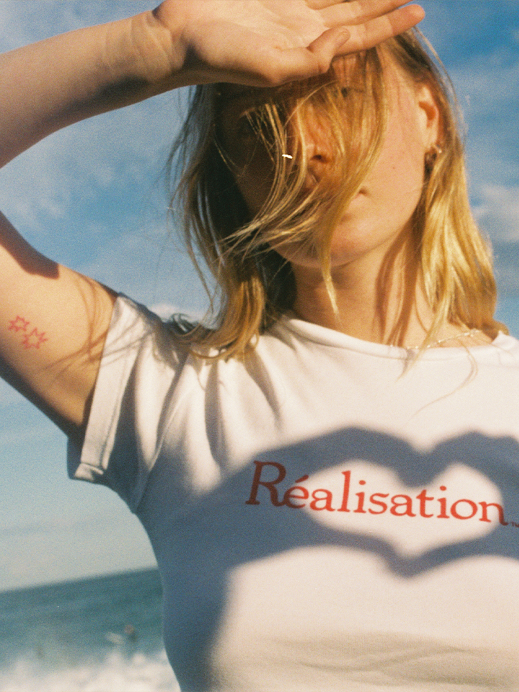 Realisation Logo Tee, White Baby Tee with Red Logo