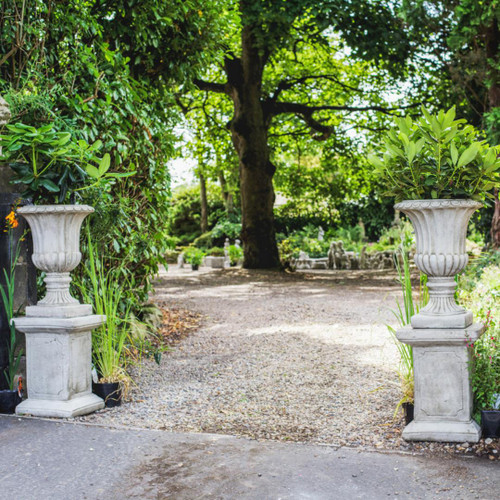 Pair of Large Stone Cast Flute Urns and Classic Plinths Pair of Large Stone Cast Flute Urns and Classic Plinths