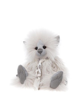 A fluffy white Charlie Bears teddy bear with grey suede paws, nose, and ears sits upright, adorned with a braided white ribbon tie, against a plain white background.