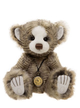 A striped grey-brown Charlie Bear teddy sits upright against a white background, wearing a vintage brass pocket watch on a cord necklace. It has white paw pads and a white muzzle.