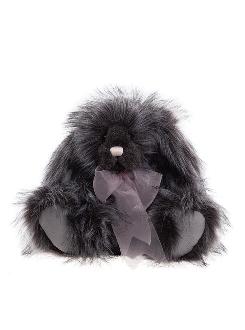 A dark grey, long-haired plush bunny rabbit sits upright against a white background, adorned with a sheer lavender ribbon bow at its chest.