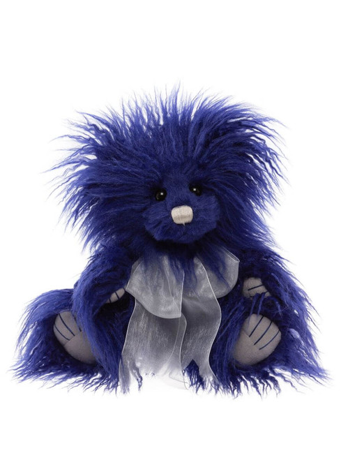 A fluffy, deep blue Charlie Bears teddy bear sits upright, featuring wild, shaggy fur, small black eyes, a cream nose, pale paw pads, and a sheer white organza ribbon bow tied at its chest.