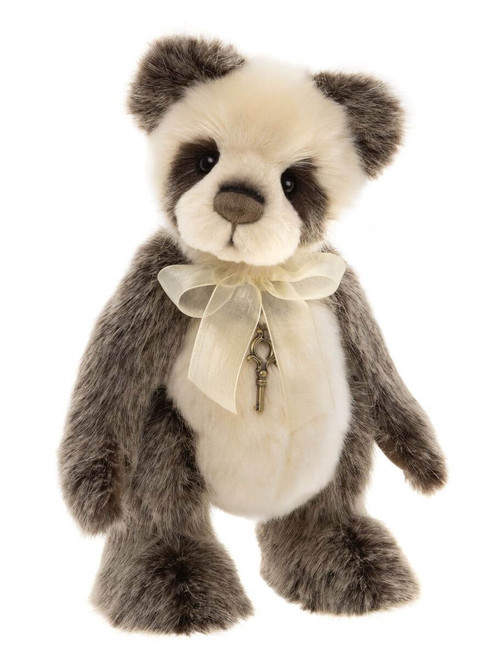 A panda-style Charlie Bear stands upright against a white background, wearing a cream organza bow with a small antique brass key charm pendant.